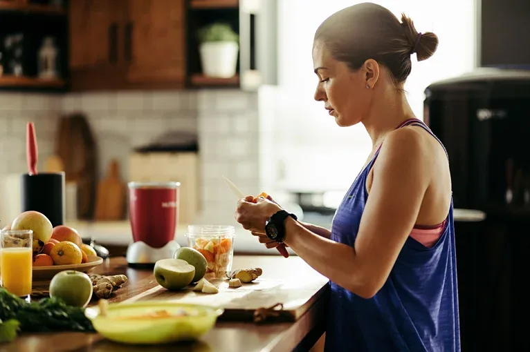Woman in a table making fruits shake.