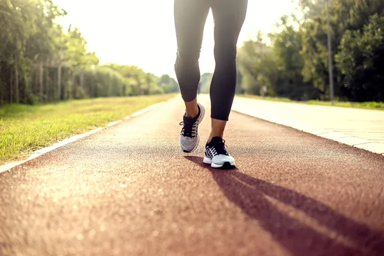 Lower legs shown for a person doing walking exercise on the road.
